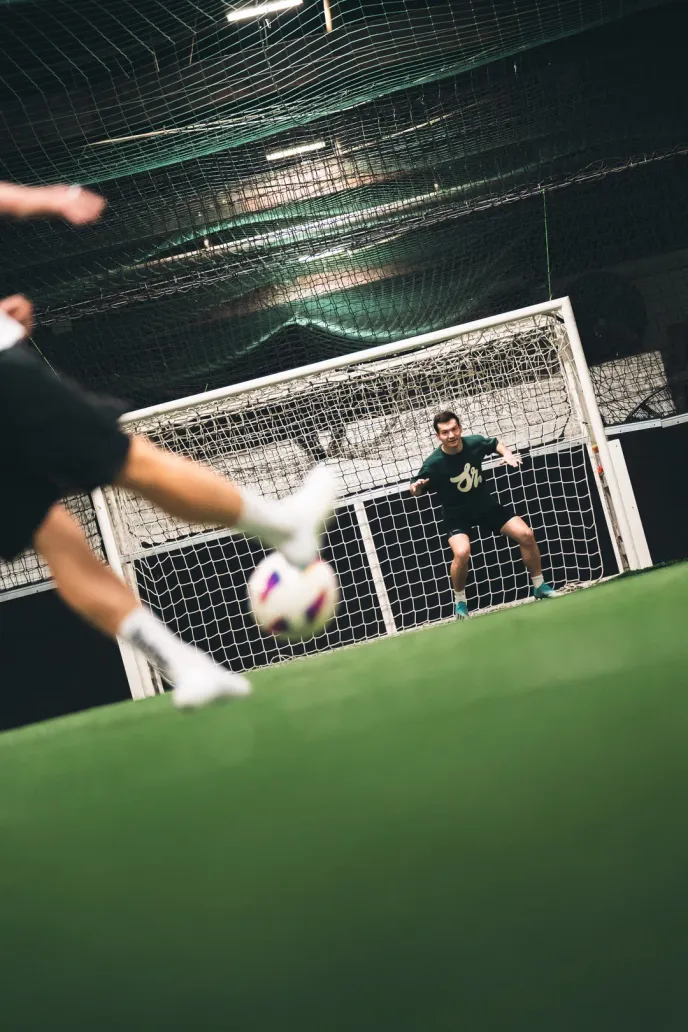 A player tries to score against a well-defended cage