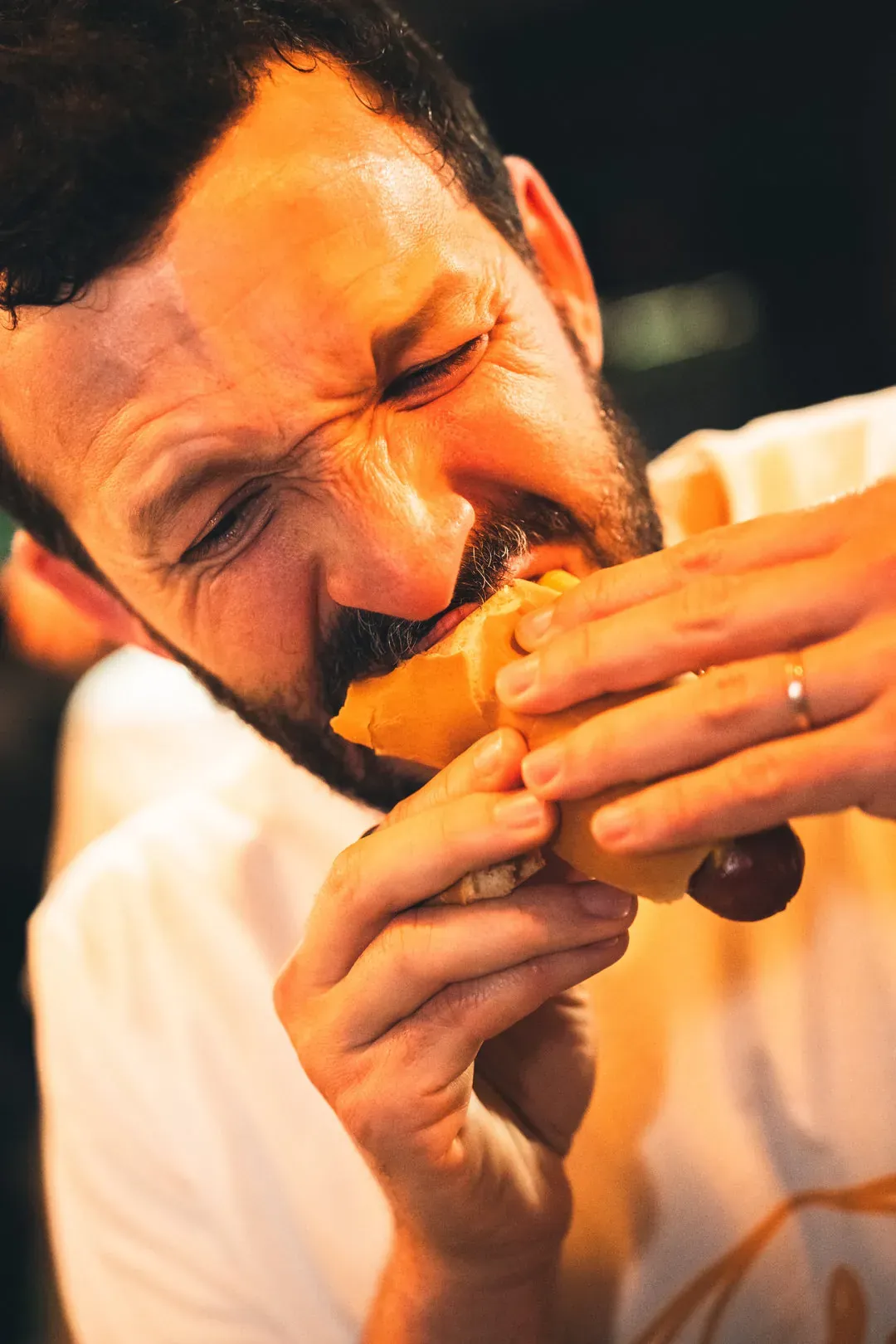 Un homme mange un hot-dog avec appétit