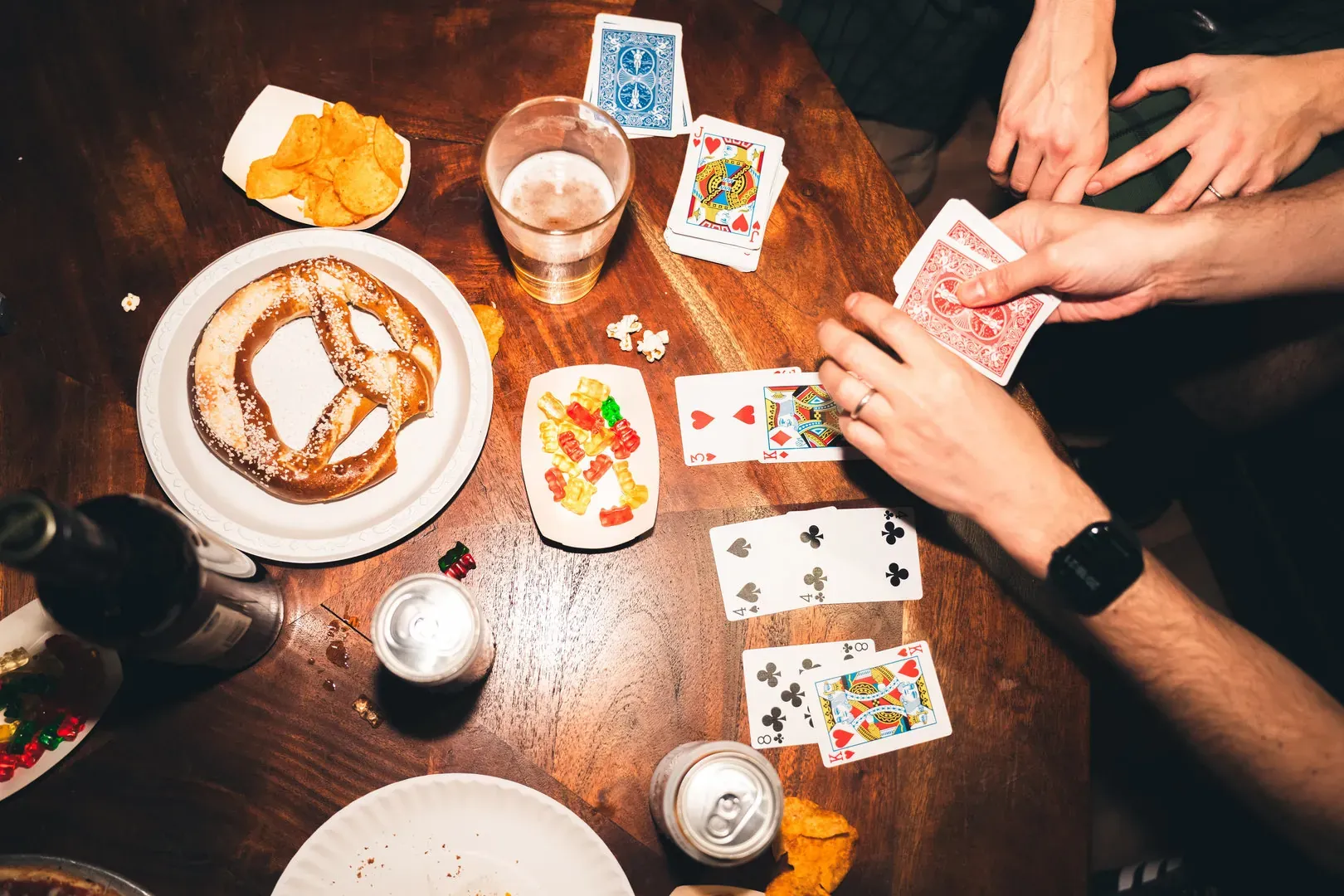 Des amis jouent aux cartes en prenant un verre